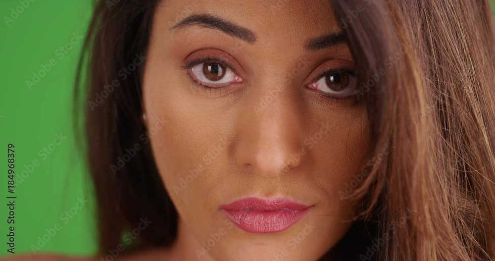 Close up of sultry Latina female looking at camera confidently on green screen. On green screen to be keyed or composited. Close up of sultry Latina female looking at camera confidently on green screen. On green screen to be keyed or composited.