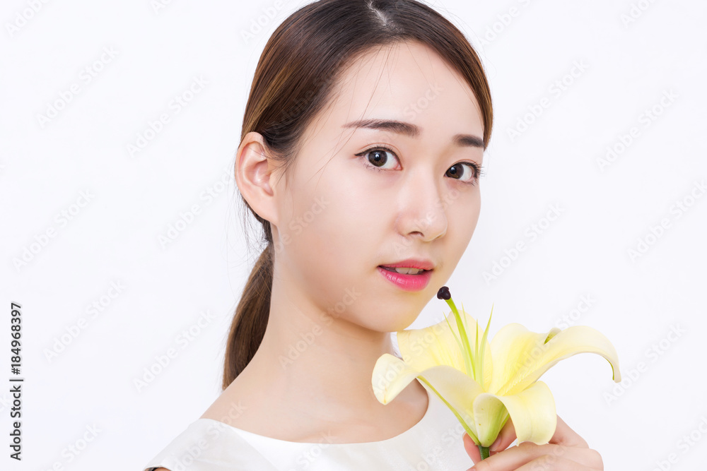 Closeup of beautiful young woman holding a yellow lily Closeup of beautiful young woman holding a yellow lily