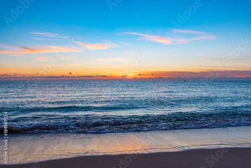 bright colorful sky reflection off the ocean on a calm morning at the beach