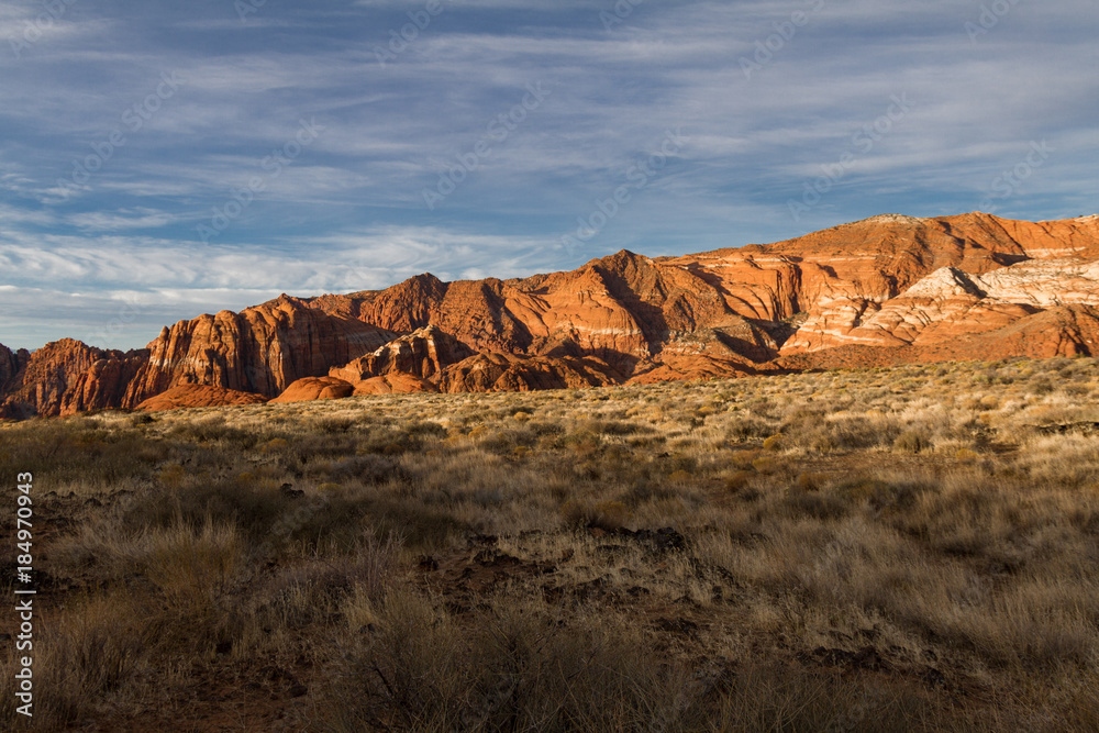 Fototapeta premium Wonderful sun lit red Navajo sandstone mountains in Snow Canyon State Park in Utah.
