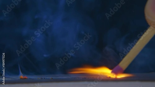 The match in the hand moves on the side of the matchbox and light the fire. S-log - High Dynamic Range. Macro. Slow mo, slo mo, slow motion, high speed camera, 240fps, 250fps photo