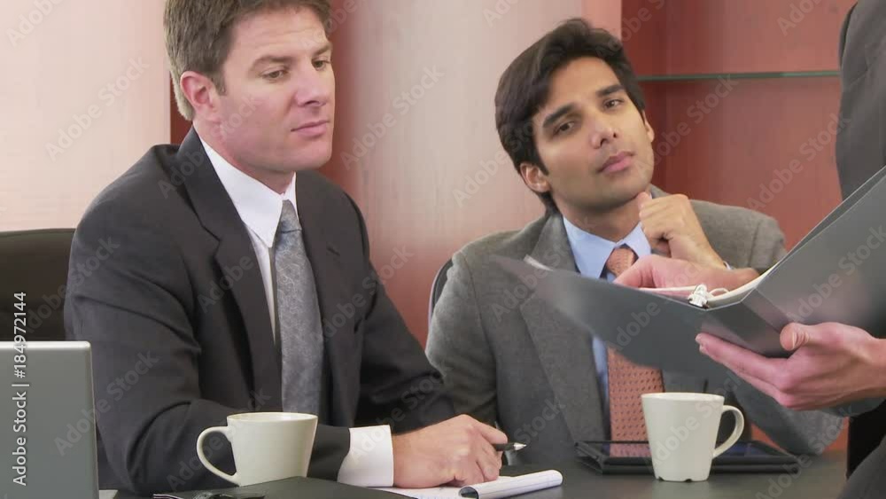 Close up of businessman talking to colleagues in office Close up of businessman talking to colleagues in office