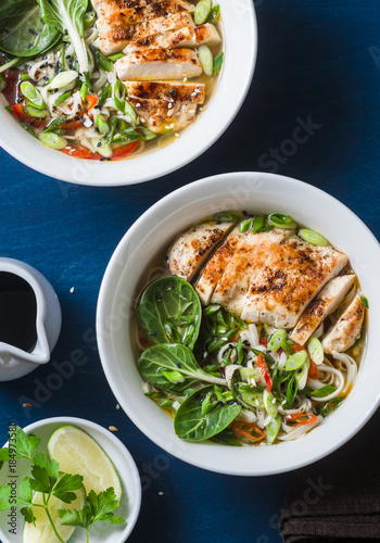 Fried chicken, noodles asian style soup on a blue background, top view