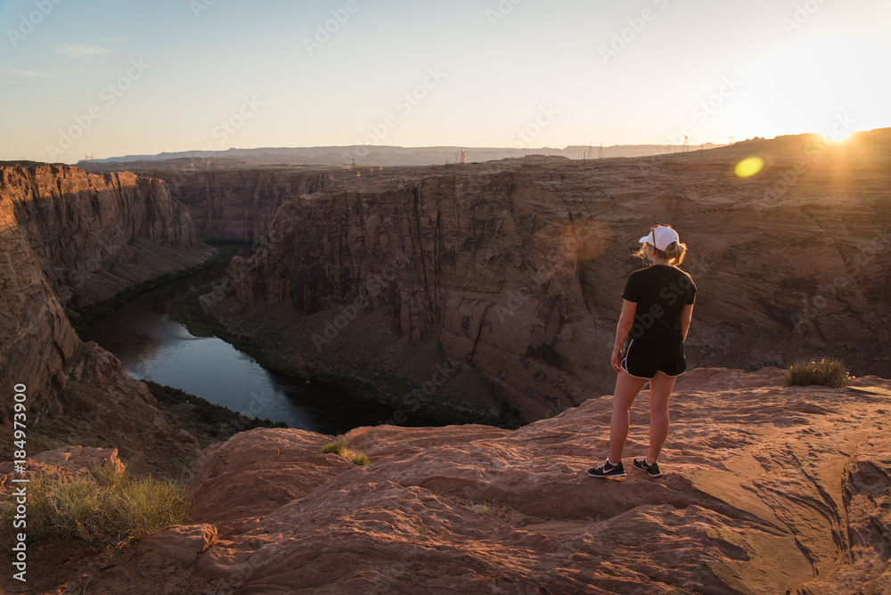 A woman standing on a cliff looking at the Colorado River in Page, Arizona. A woman standing on a cliff looking at the Colorado River in Page, Arizona.