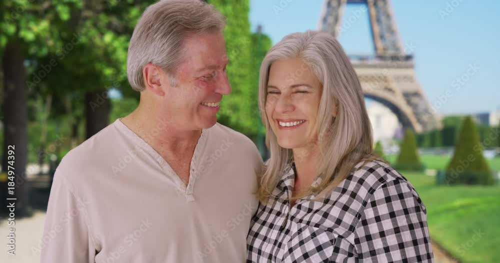 Senior Caucasian couple stand together in front of Eiffel Tower Senior Caucasian couple stand together in front of Eiffel Tower