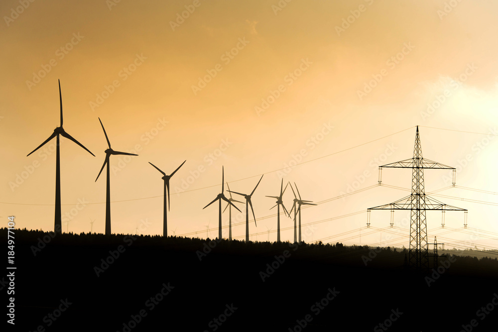 Black Silhouette of windturbines energy generator on amazing sunset at a wind farm in germany Black Silhouette of windturbines energy generator on amazing sunset at a wind farm in germany