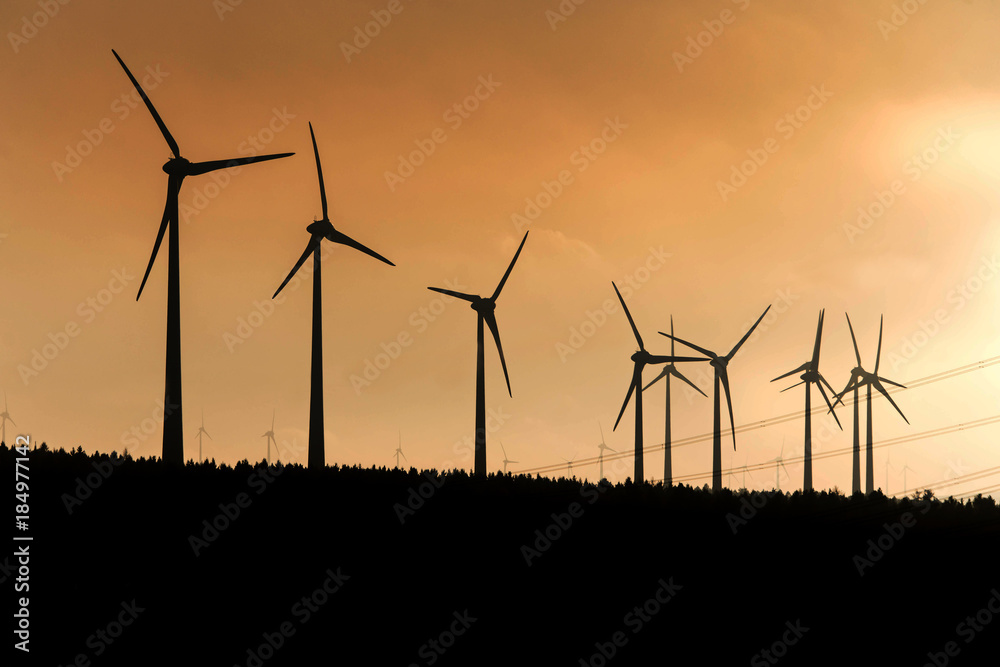 Black Silhouette of windturbines energy generator on amazing sunset at a wind farm in germany Black Silhouette of windturbines energy generator on amazing sunset at a wind farm in germany