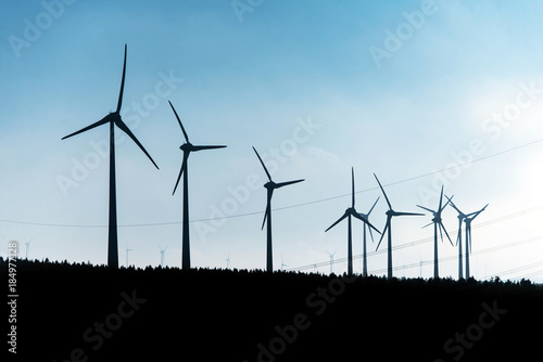 Black Silhouette of windturbines energy generator on blue sky at a wind farm in germany © CL-Medien