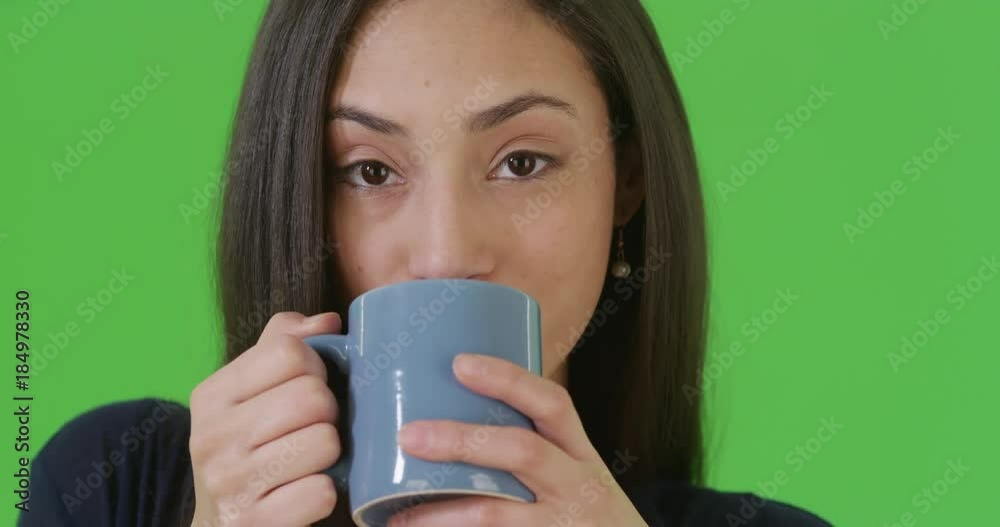 A close-up portrait of a Hispanic woman drinking coffee on green screen. On green screen to be keyed or composited. A close-up portrait of a Hispanic woman drinking coffee on green screen. On green screen to be keyed or composited.