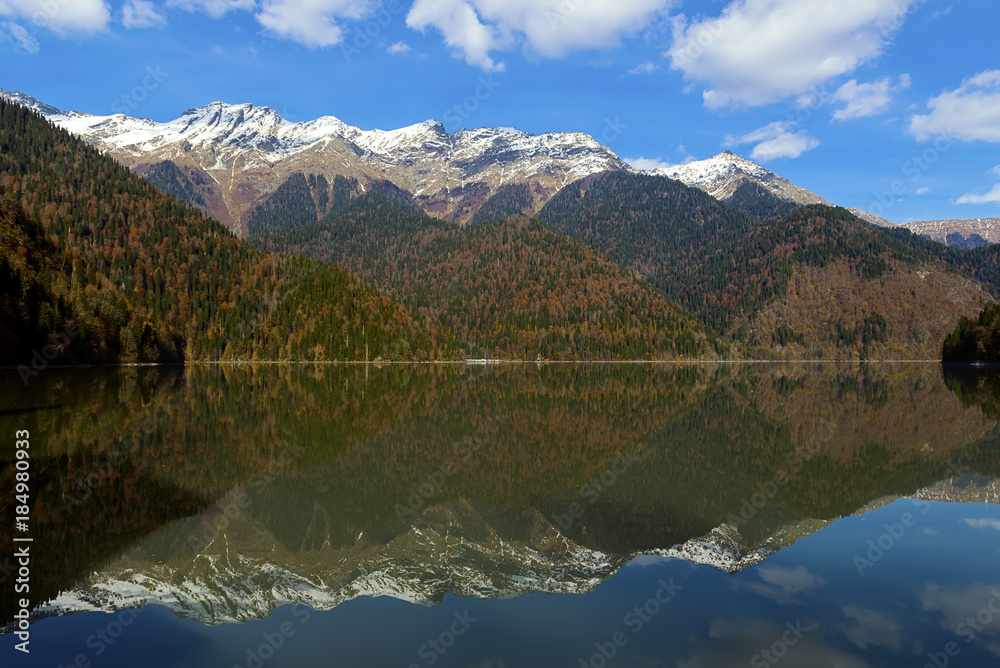 Riza lake, yellow autumn-green forest and white snow peaks