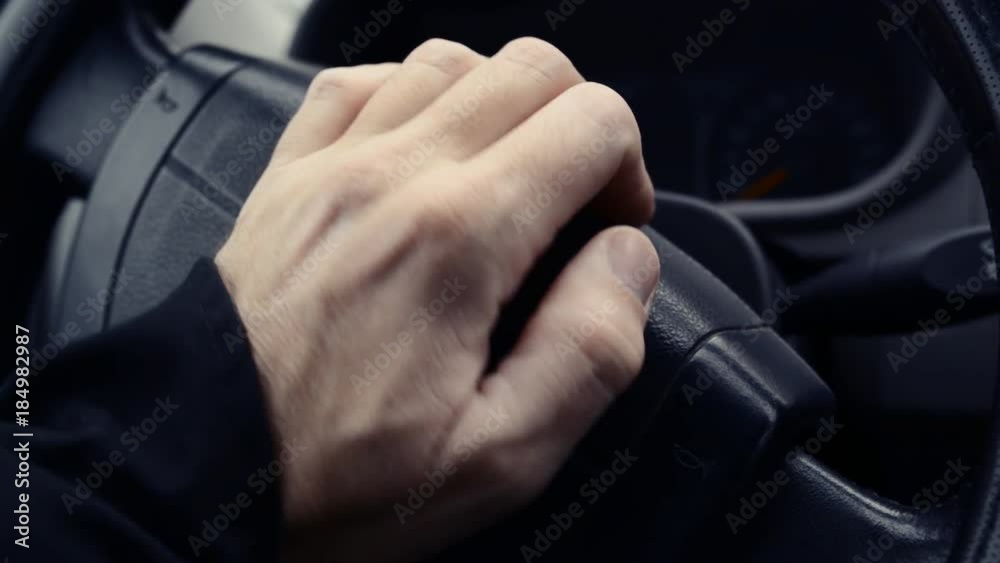 Male hand honking the car horn, man driving vehicle and beeping