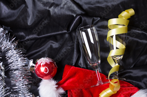 New year champaign bottle and glasses on black background with santa claus hat top view