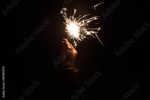 Hand holding sparkle dark sky
