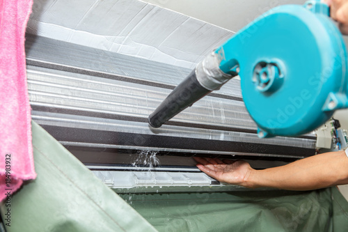 Technician man dry up and dust cleaning air Conditioner filter with electric blowers