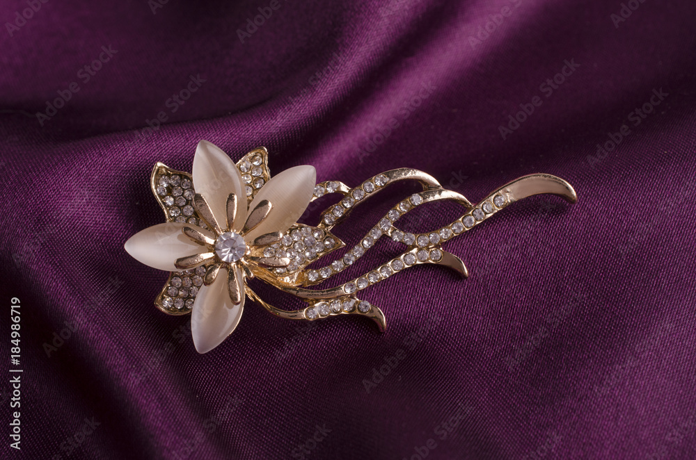 gold brooch flower with gems and moon stone on silk gold brooch flower with gems and moon stone on silk