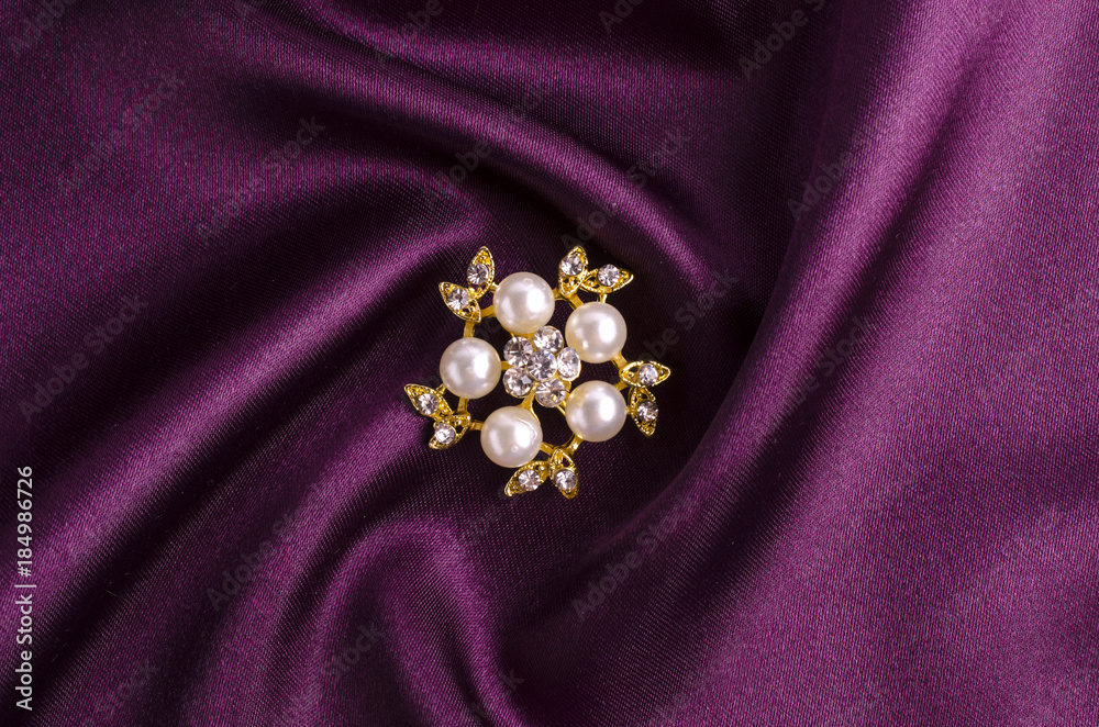 gold brooch flower with pearl isolated on silk gold brooch flower with pearl isolated on silk