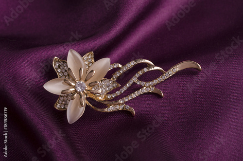 gold brooch flower with gems and moon stone on silk