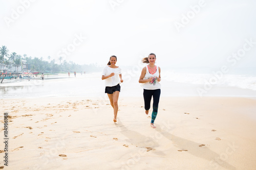 two women is jogging the seashore on an overcast day