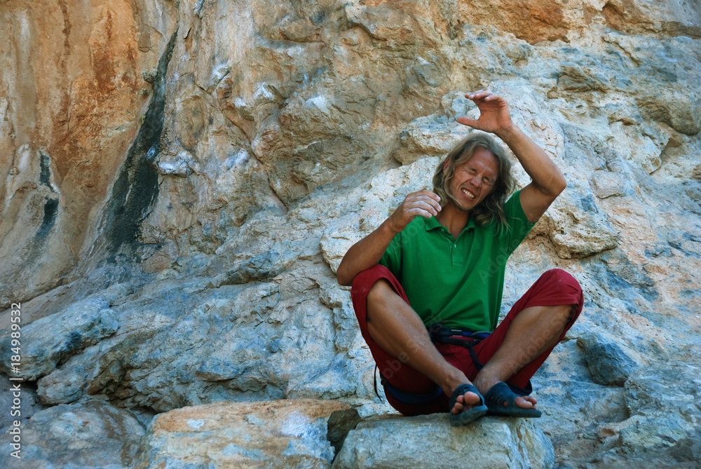 A young climber mentally climbs the rock A young climber mentally climbs the rock