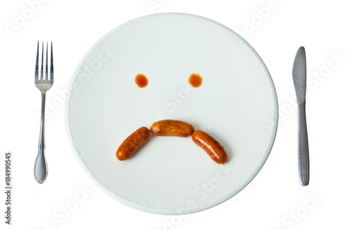 Sad face sausage on the dish