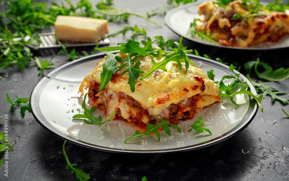 Homemade lasagna with minced beef bolognese and bechamel sauce topped wild arugula, parmesan cheese Homemade lasagna with minced beef bolognese and bechamel sauce topped wild arugula, parmesan cheese
