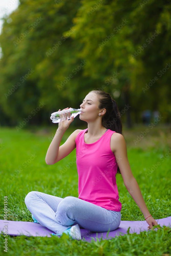 Beautiful fitness athlete woman resting drinking water outdoor Beautiful fitness athlete woman resting drinking water outdoor