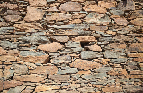 outer wall of a house made of flat red rock photo
