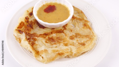 Malaysian favorite breakfast meal. Roti canai or flatbread with dhal curry isolated on white