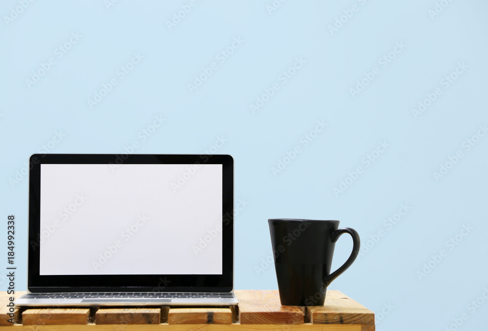 Laptop computer screen and cup of coffee wall Blue backdrop.copy space. Laptop computer screen and cup of coffee wall Blue backdrop.copy space.