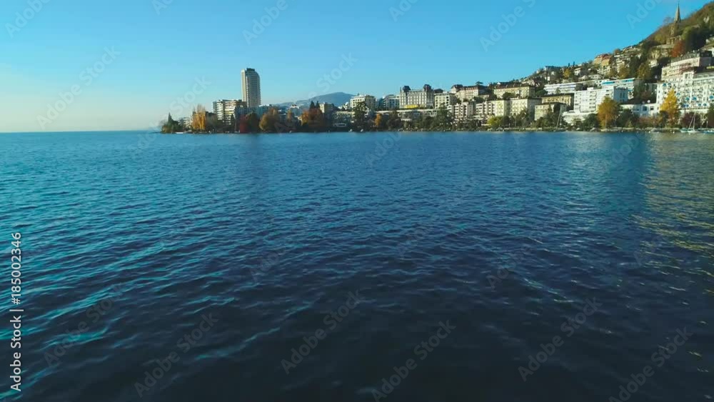 4K 50P (HFR) aerial of city of Montreux looking west over water then ascending 4K 50P (HFR) aerial of city of Montreux looking west over water then ascending