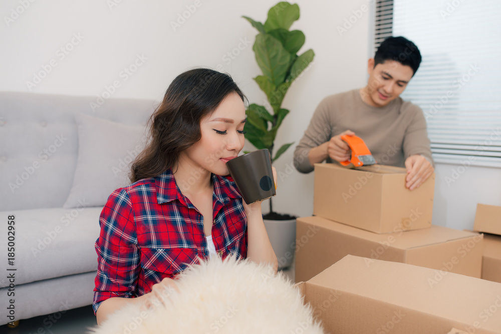 Happy young couple moving into new apartment with packaging boxes Happy young couple moving into new apartment with packaging boxes