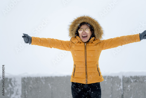 Asian woman in the colorful yellow coat enjoy snow & view of gronergrat Switzerland photo