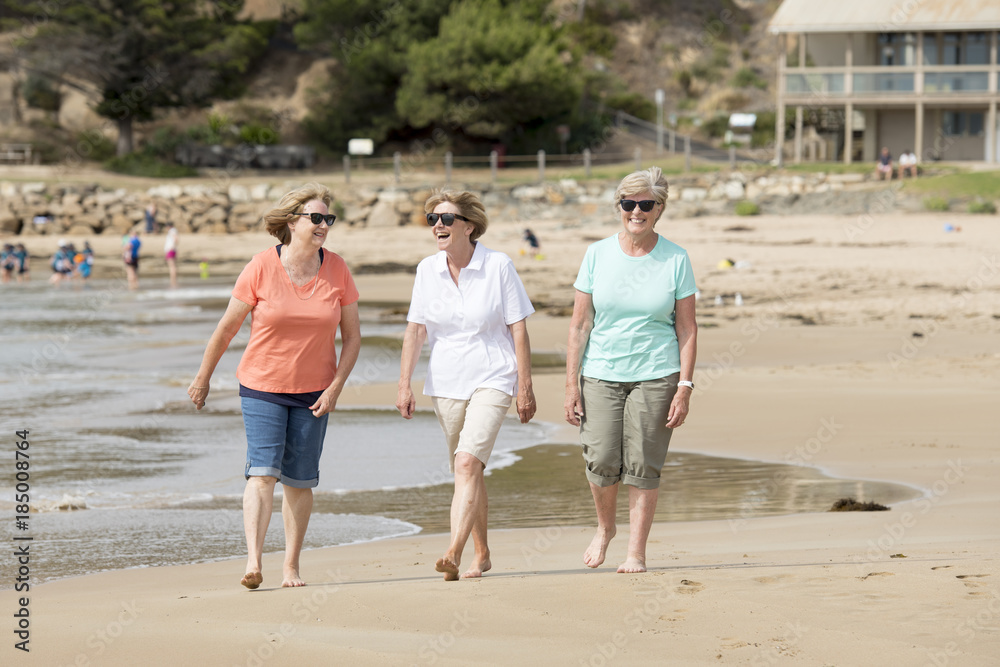 group of three senior mature retired women on their 60s having fun enjoying together happy walking on the beach smiling playful group of three senior mature retired women on their 60s having fun enjoying together happy walking on the beach smiling playful