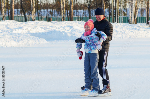 Father and daughter ice skating