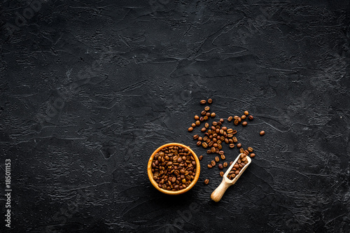 Coffee background. Roasted beans in bowl and scoop on black table top view © 9dreamstudio