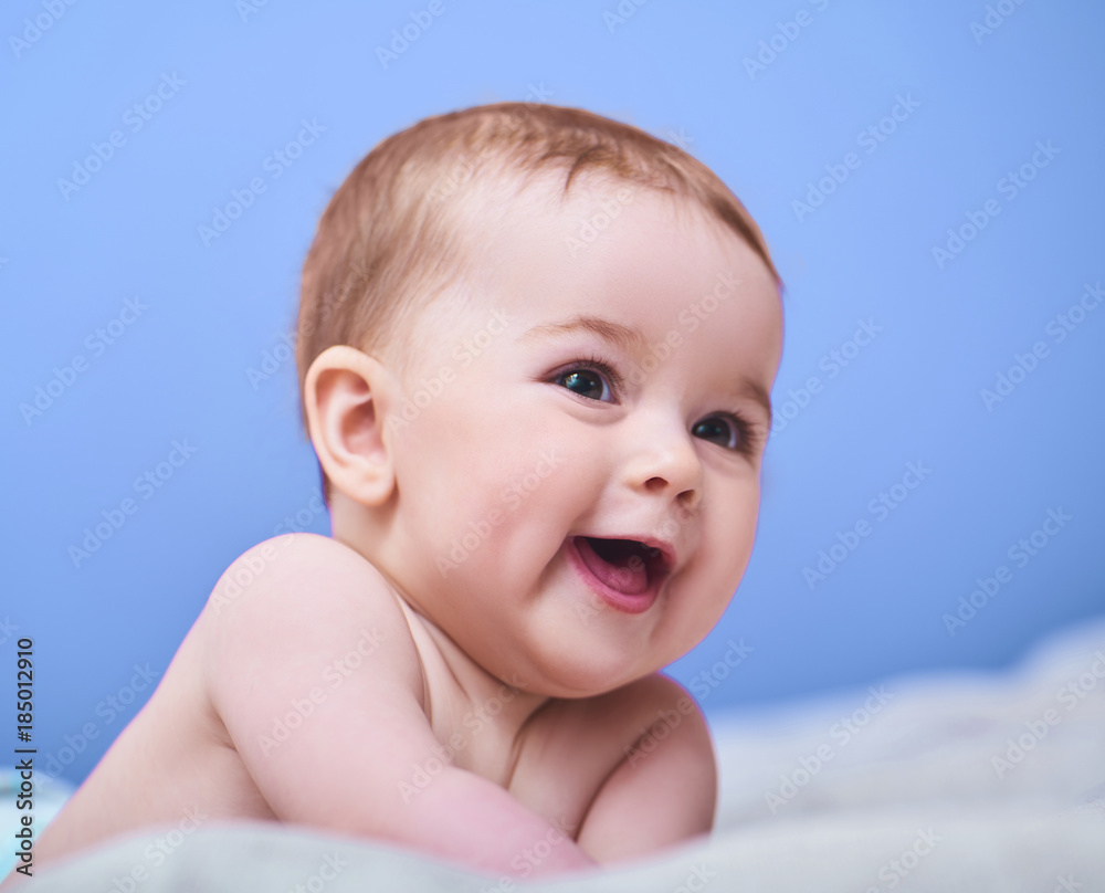 Portrait of a smiling crawling baby over blue background. Space for text Portrait of a smiling crawling baby over blue background. Space for text