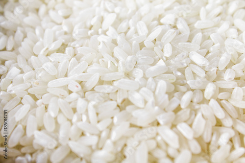 Grains of raw white rice on a white wooden table of boards. Ingredients for cooking. © detry26
