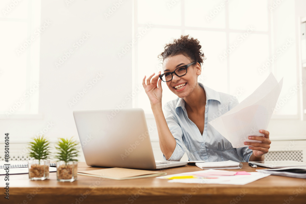 Happy business woman reading document at office desktop Happy business woman reading document at office desktop