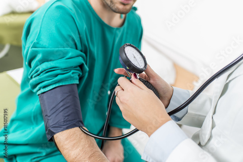 Female doctor checking blood pressure of a patient