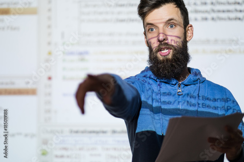 Elocution or speech craft courses. Bearded young male orator interacts with someone in the audience pointing a finger. Dialogue, discussion and rhetoric basics concept