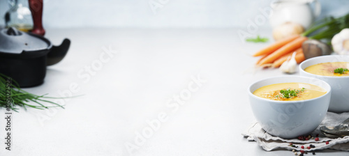 Vegetable cream soup in bowl over grey concrete background