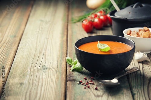 Fotografie Homemade tomato soup (or gazpacho) over old wooden background