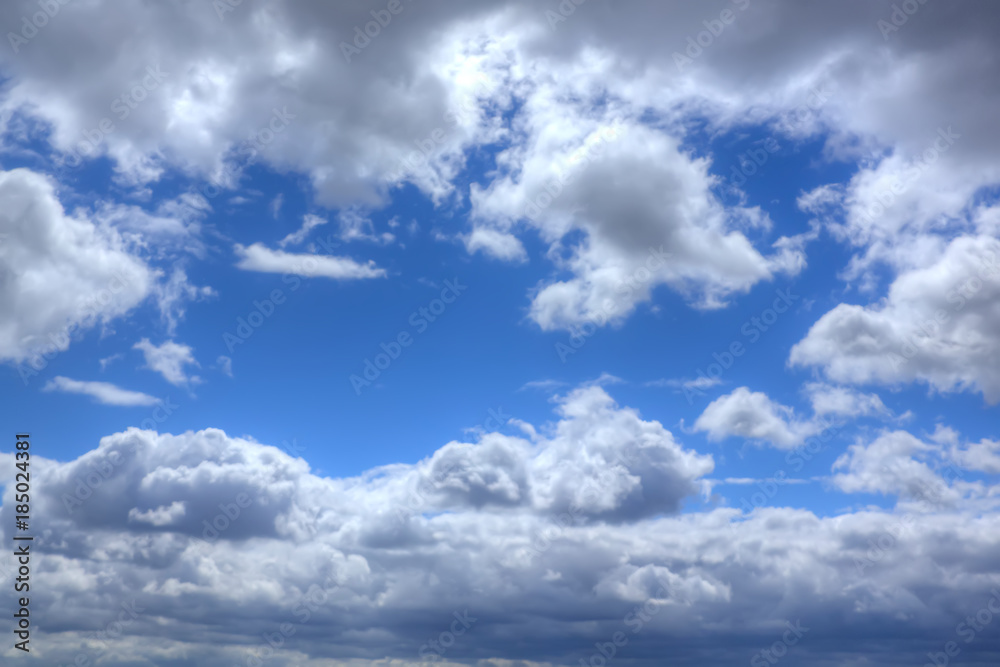 White clouds in the blue sky on a sunny day.