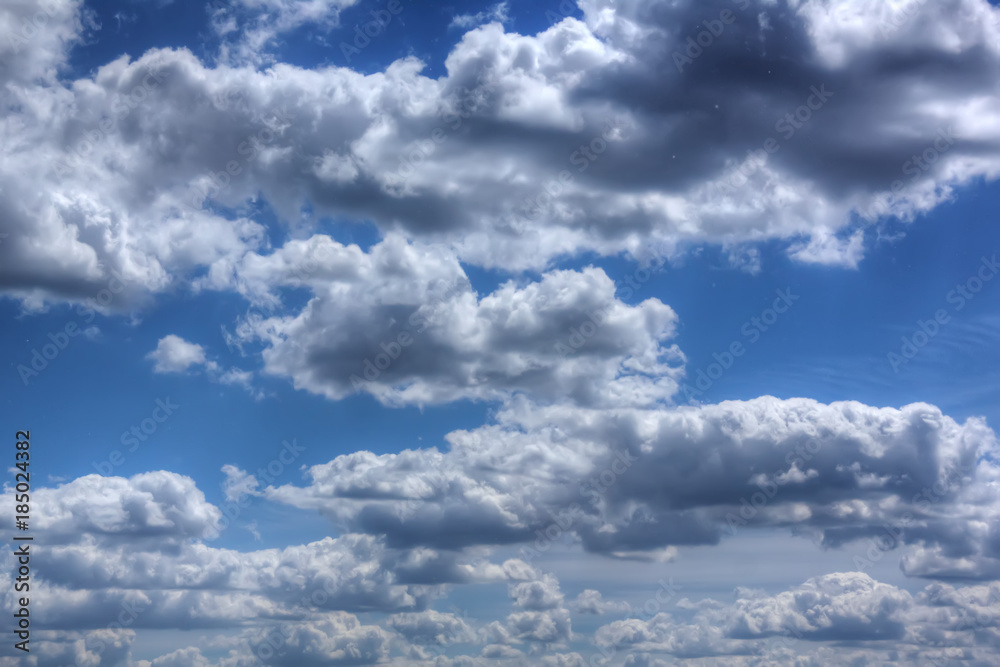 White clouds in the blue sky on a sunny day.