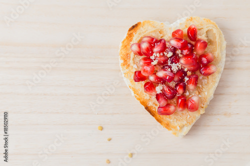 Valentine's day concept, toast heart pomegranate seeds, copy space