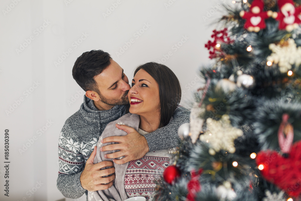 Kissing next to Christmas tree Kissing next to Christmas tree