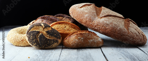 Different kinds of bread and bread rolls on wooen backgroundKitchen or bakery poster design photo