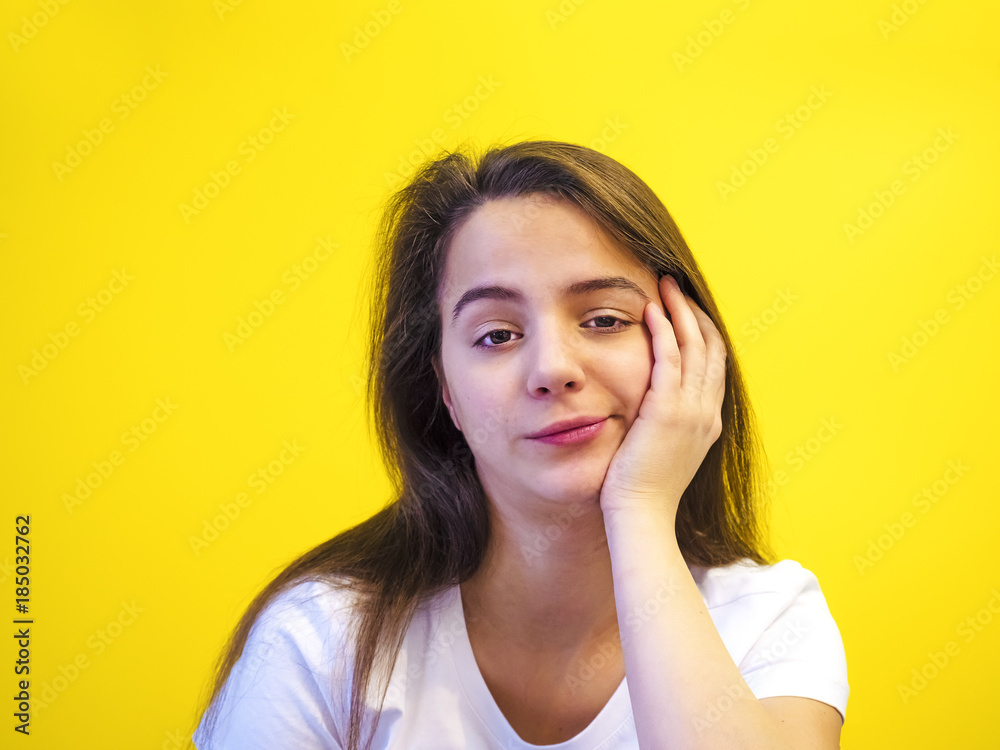 Pretty European young troubled and thoughtful black-haired woman with healthy clean skin, dressed in a white T-shirt, pondering and guessing, on a stylized background. The concept of emotions. Pretty European young troubled and thoughtful black-haired woman with healthy clean skin, dressed in a white T-shirt, pondering and guessing, on a stylized background. The concept of emotions.