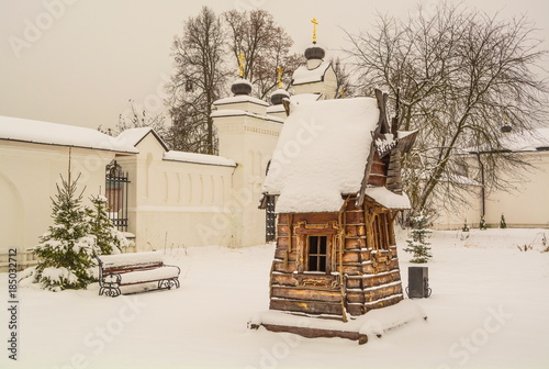 fairy-tale wooden mill in winter courtyard of Orthodox monastery photo