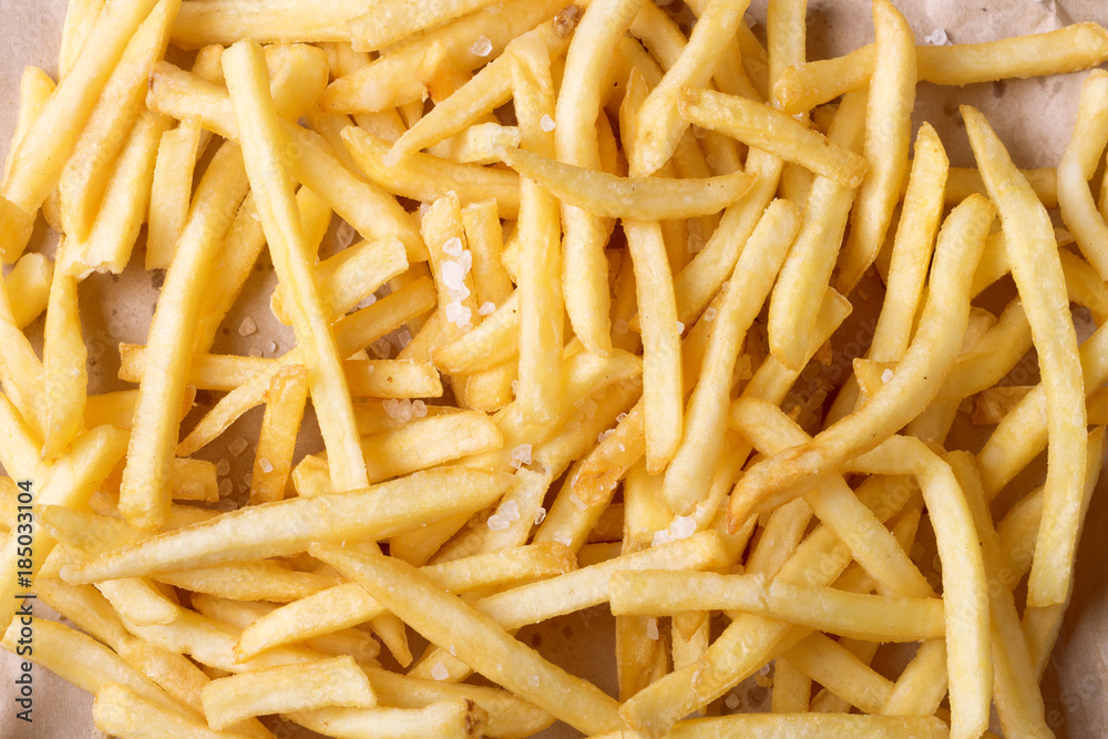 french fries background, potatoes chips with salt. close-up shot. top view french fries background, potatoes chips with salt. close-up shot. top view